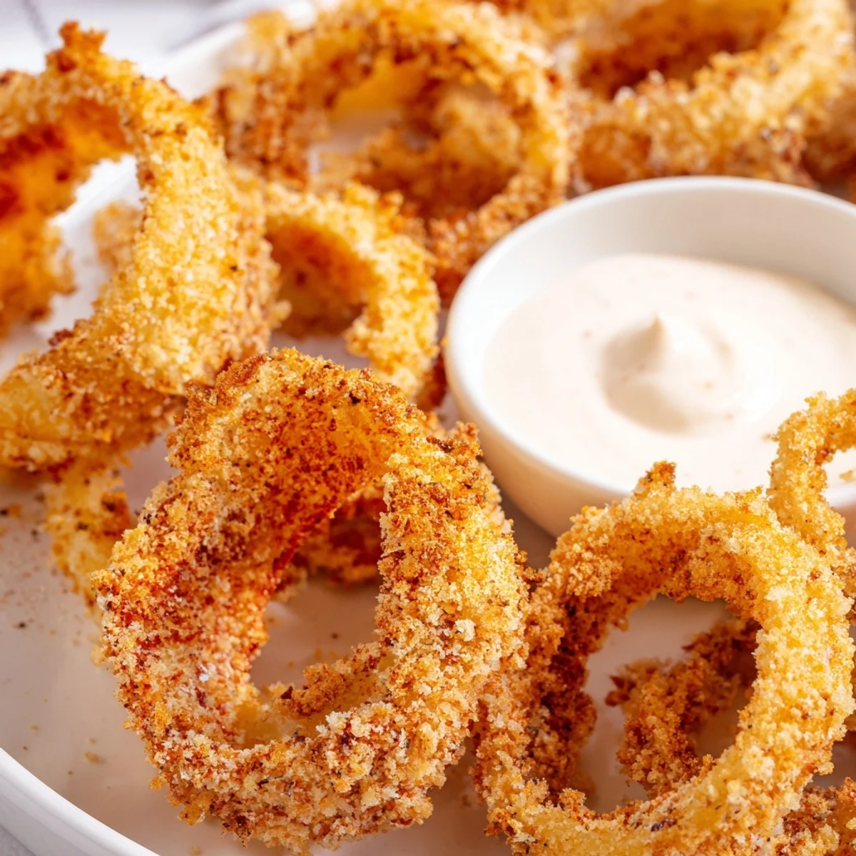 Close-up of crispy air fryer onion rings, a side dish served hot and ready to enjoy.