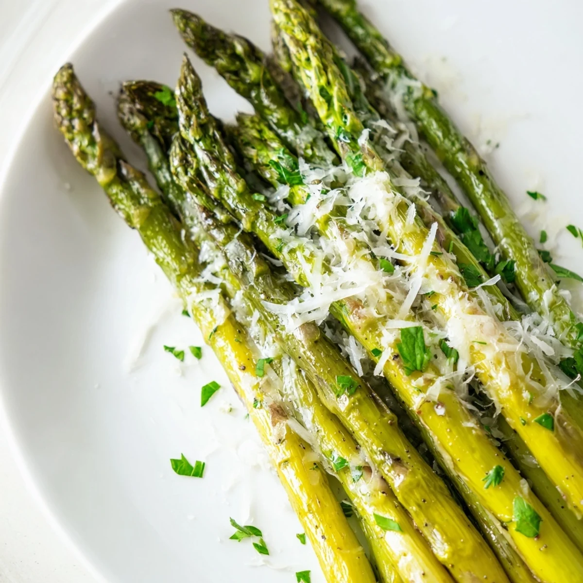 Roasted asparagus with Parmesan cheese on a rustic table, garnished with lemon wedges and fresh parsley for a flavorful side.
