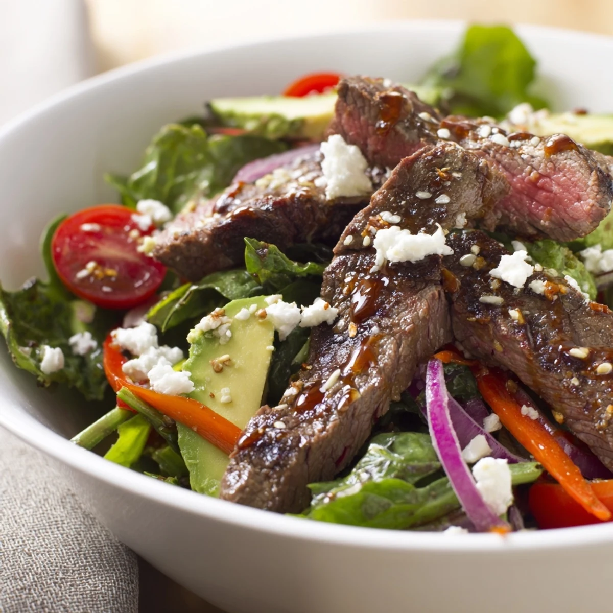 Colorful cherry tomatoes, creamy avocado, and a drizzle of zesty balsamic dressing garnish this easy Beef Salad Bowl for a light meal. 