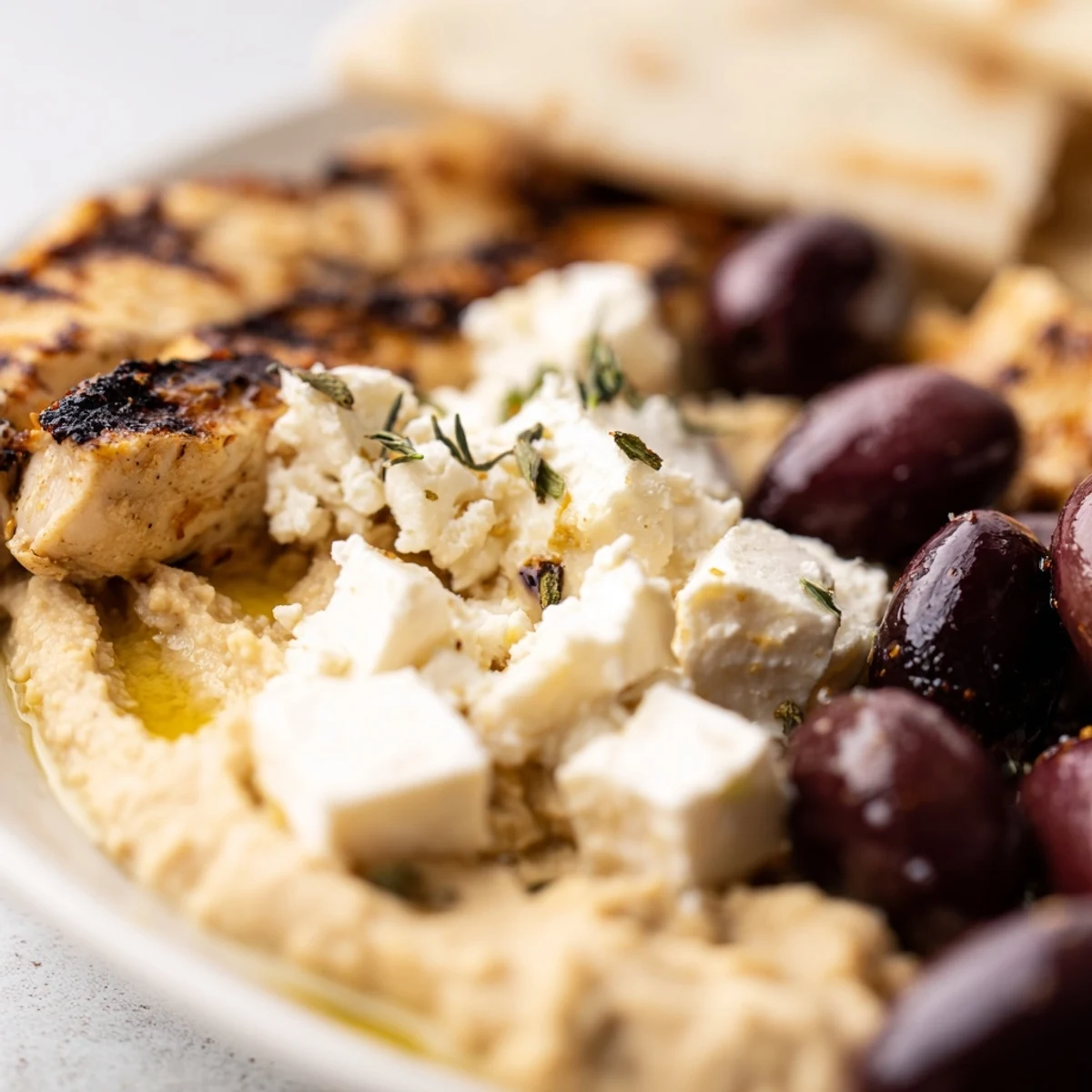 Overhead view of a Mediterranean Dish Platter with assorted dips, marinated olives, and fresh parsley garnish.