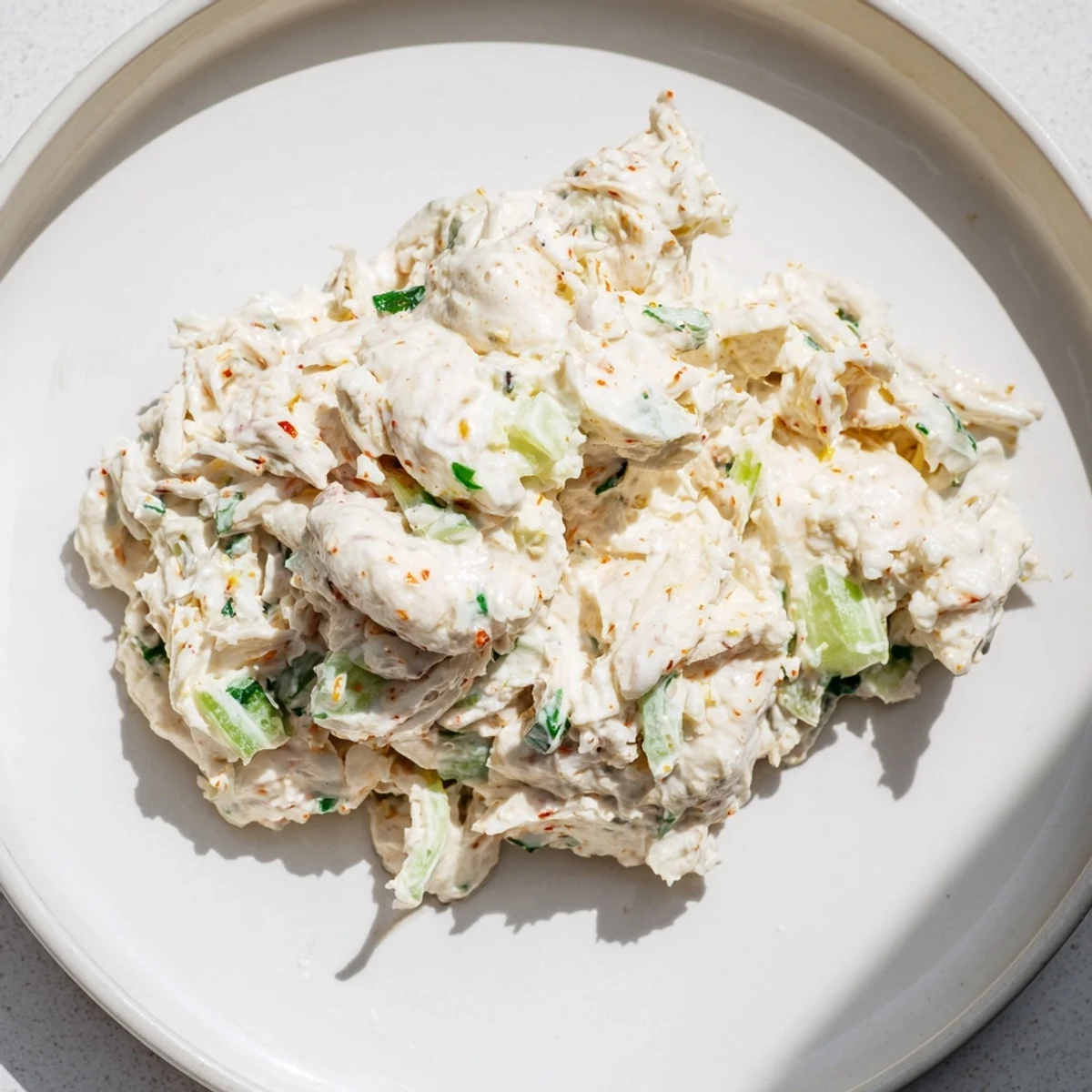 Creamy remoulade sauce with sweet crab meat garnished with fresh herbs, perfect as a zesty dip or sandwich spread.  