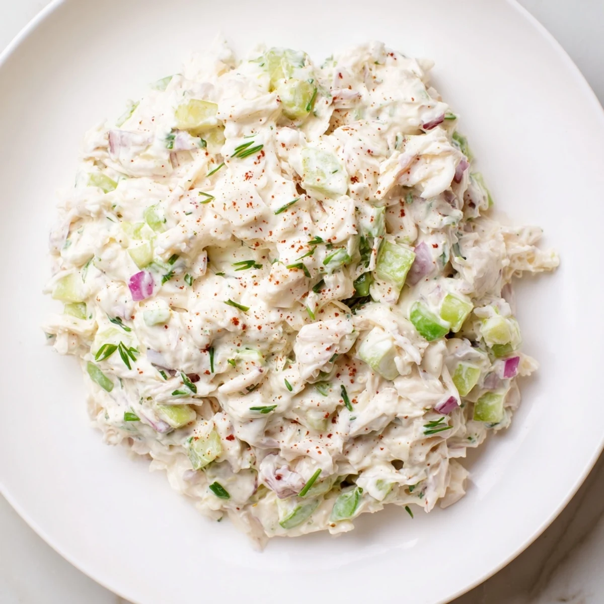 Remoulade sauce topped with crab meat and herbs, served alongside crispy French fries and lemon wedges for a zesty dip.  