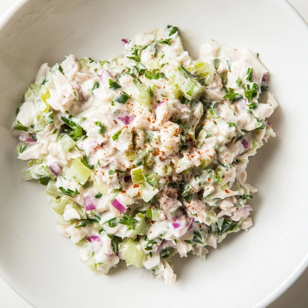 A bowl of creamy remoulade sauce with fresh lump crab meat and chopped herbs, perfect for dipping chilled shrimp.  