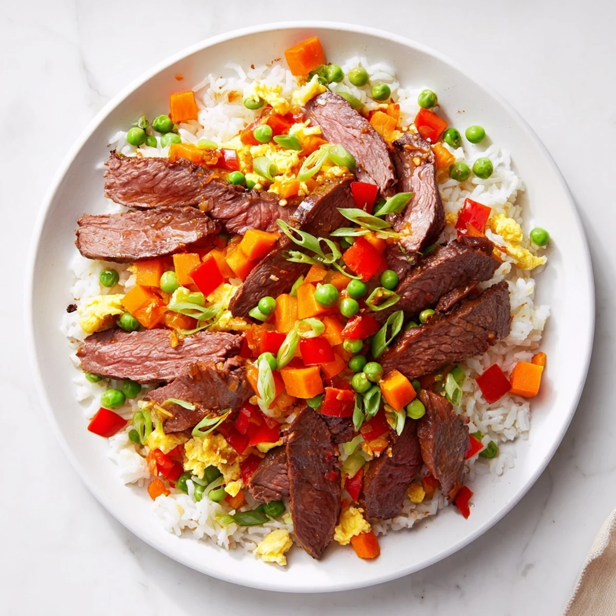 Beef Fried Rice with Vegetables piled on a plate beside chopsticks, highlighting the savory aroma and mix of beef, veggies, and jasmine rice.