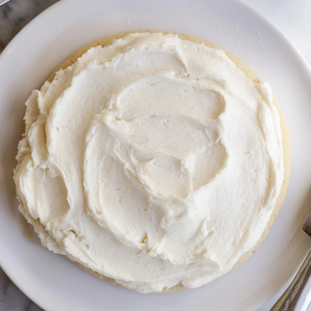 Homemade Easy Sugar Cookie Frosting showing rich buttercream consistency, ideal for topping cookies and cupcakes in a home kitchen.