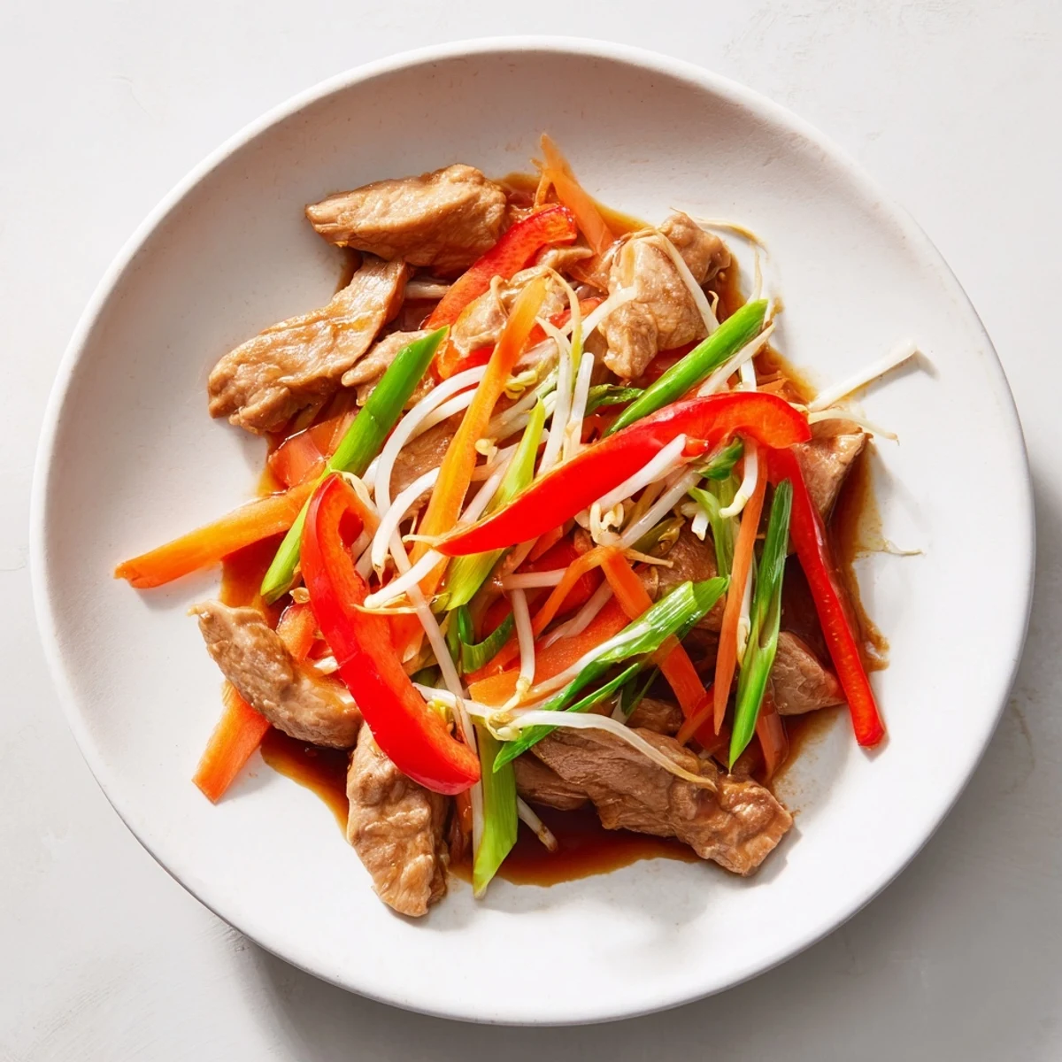 Golden-brown Peking Style Chicken stir-fry with crisp red bell peppers, julienned carrots, and fresh bean sprouts glistening in savory sauce.