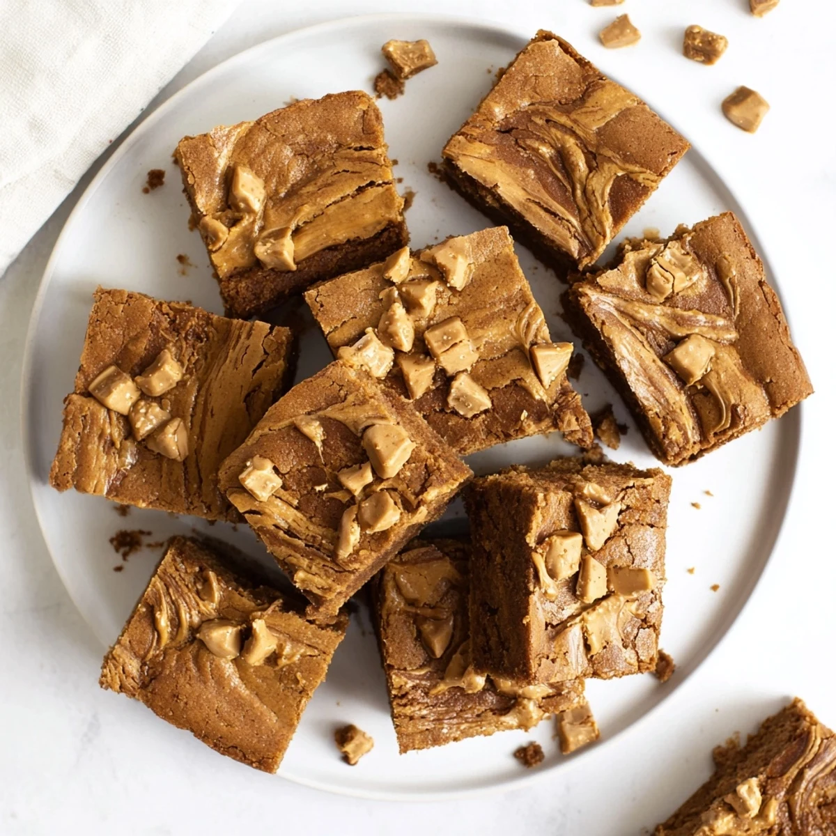 Freshly baked Brown Butter Biscoff Blondies are displayed on a wire rack, showcasing their golden edges and soft, chewy centers.  