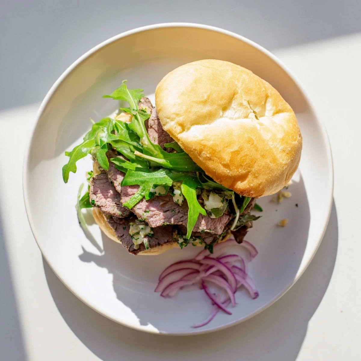Sizzling Cowboy Butter Steak Sliders ready for game day, featuring pink sliced steak and fresh herbs on buns.