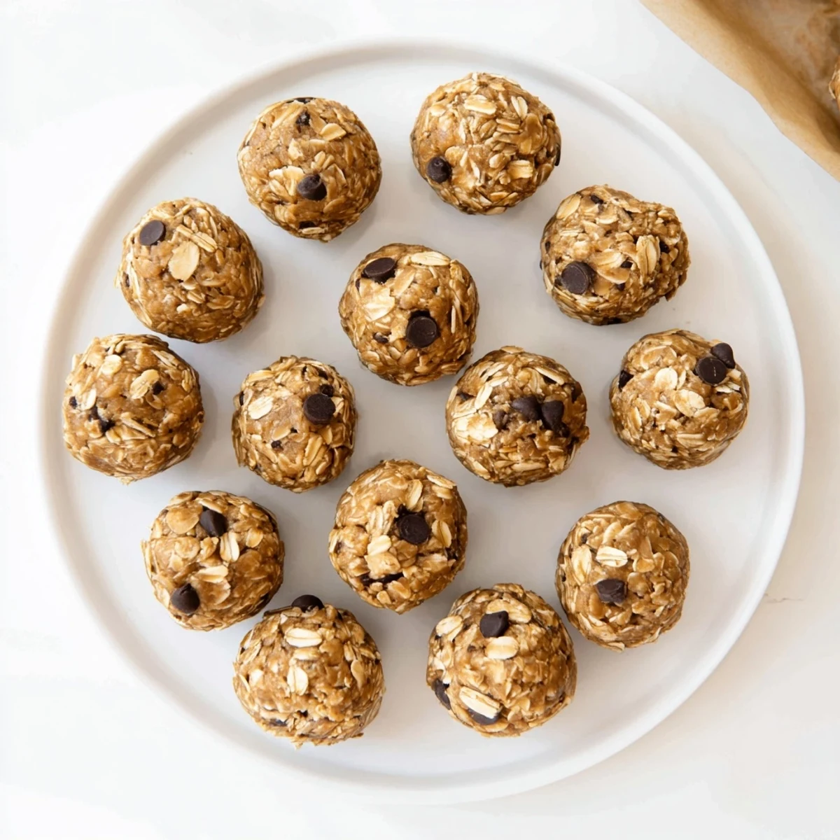 No Bake Peanut Butter Energy Bites sit on a wooden board, ready to serve as a quick, wholesome vegan snack.
