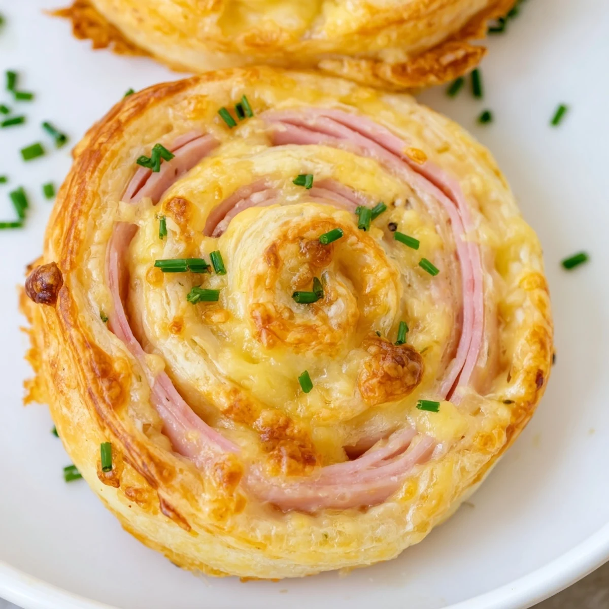 Golden brown Easter Ham Cheddar Pinwheels with flaky pastry layers and melted cheddar cheese
