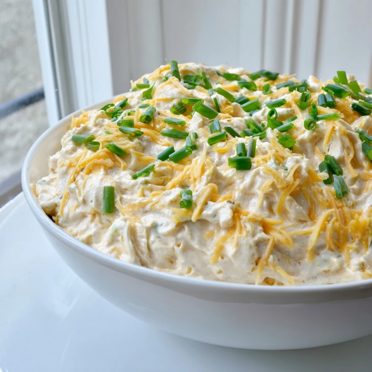 Rich savory pretzel dip garnished with green onions, ready for party appetizer serving