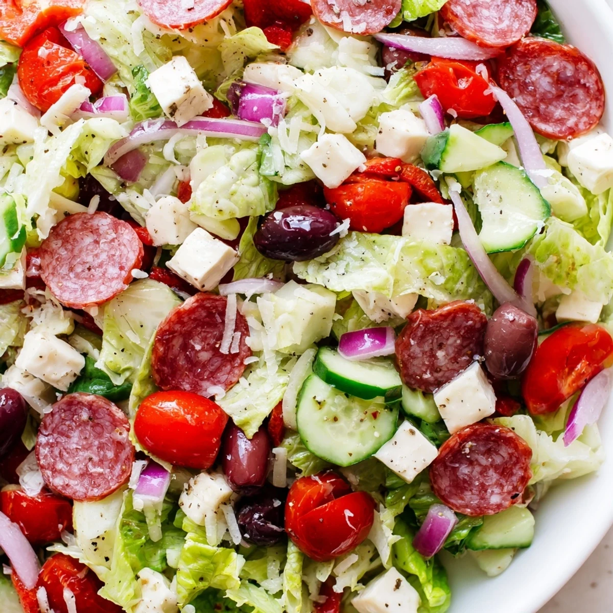 Fresh Italian chopped salad with pepperoncini, roasted red peppers, and Genoa salami coated in homemade Italian dressing