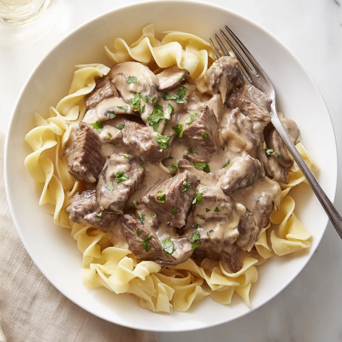 Golden beef stroganoff with tender beef strips in creamy mushroom sauce over egg noodles