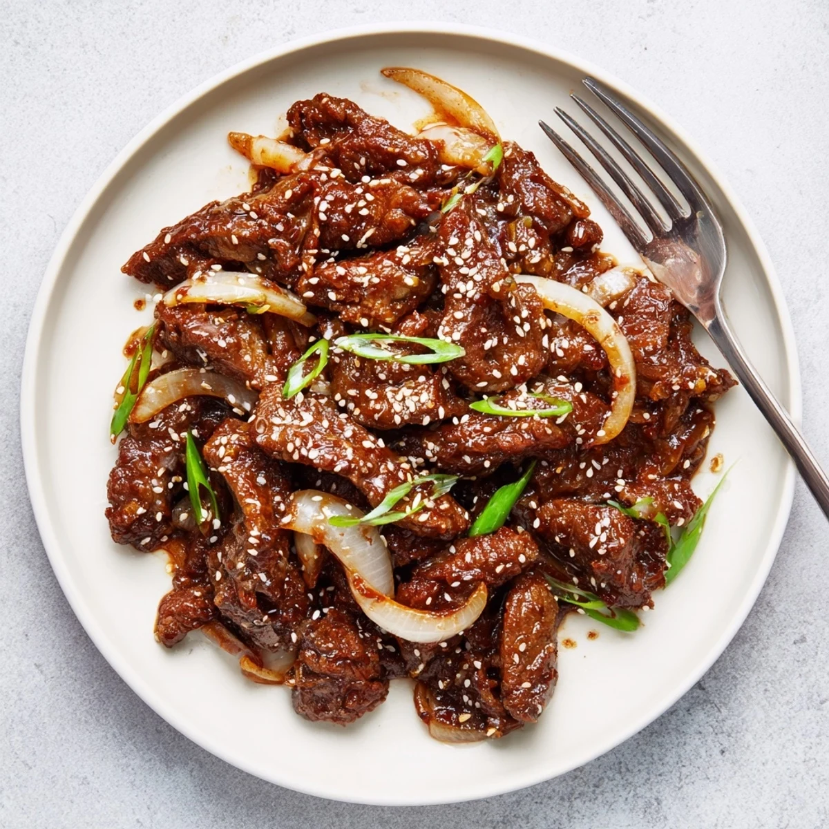 Slow cooker Korean beef served over fluffy white rice with green onion garnish