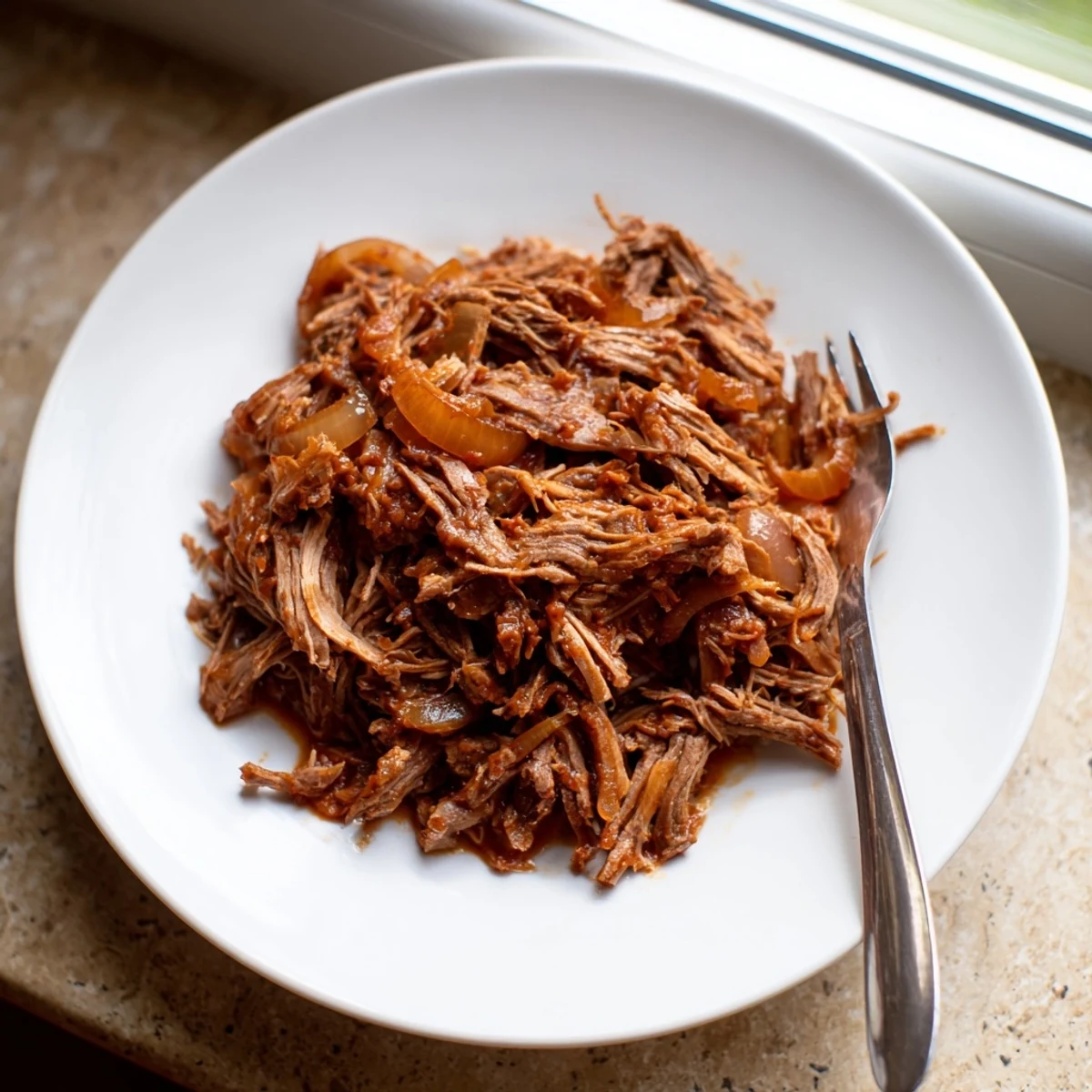 Tender Crock Pot shredded beef piled high with juicy meat and aromatic spices