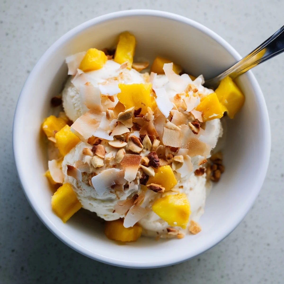 Rich dairy-free Thai coconut milk ice cream swirl with chopped roasted peanuts on a dark background