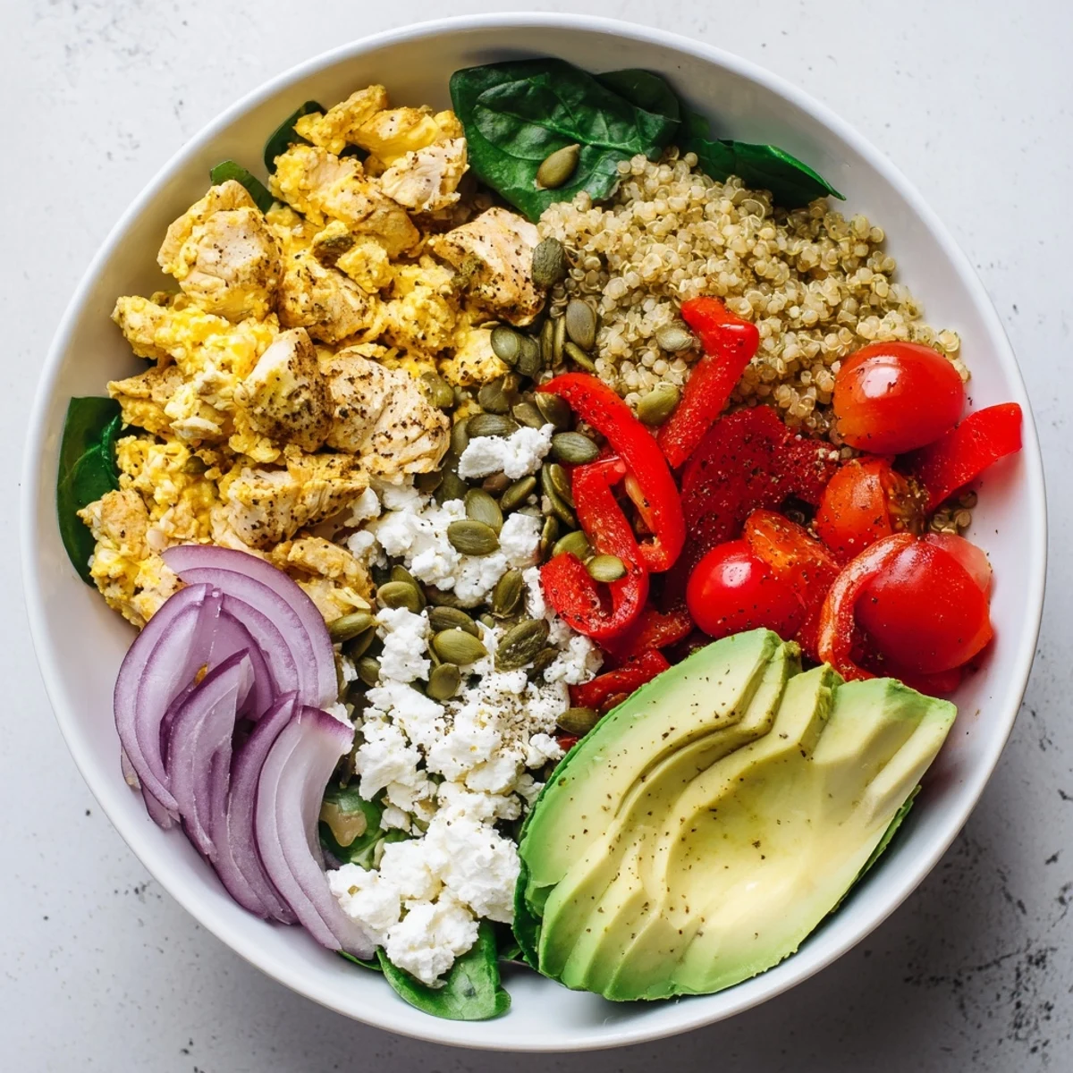 Easy high protein breakfast bowl with fluffy scrambled eggs, colorful vegetables, and creamy avocado slices