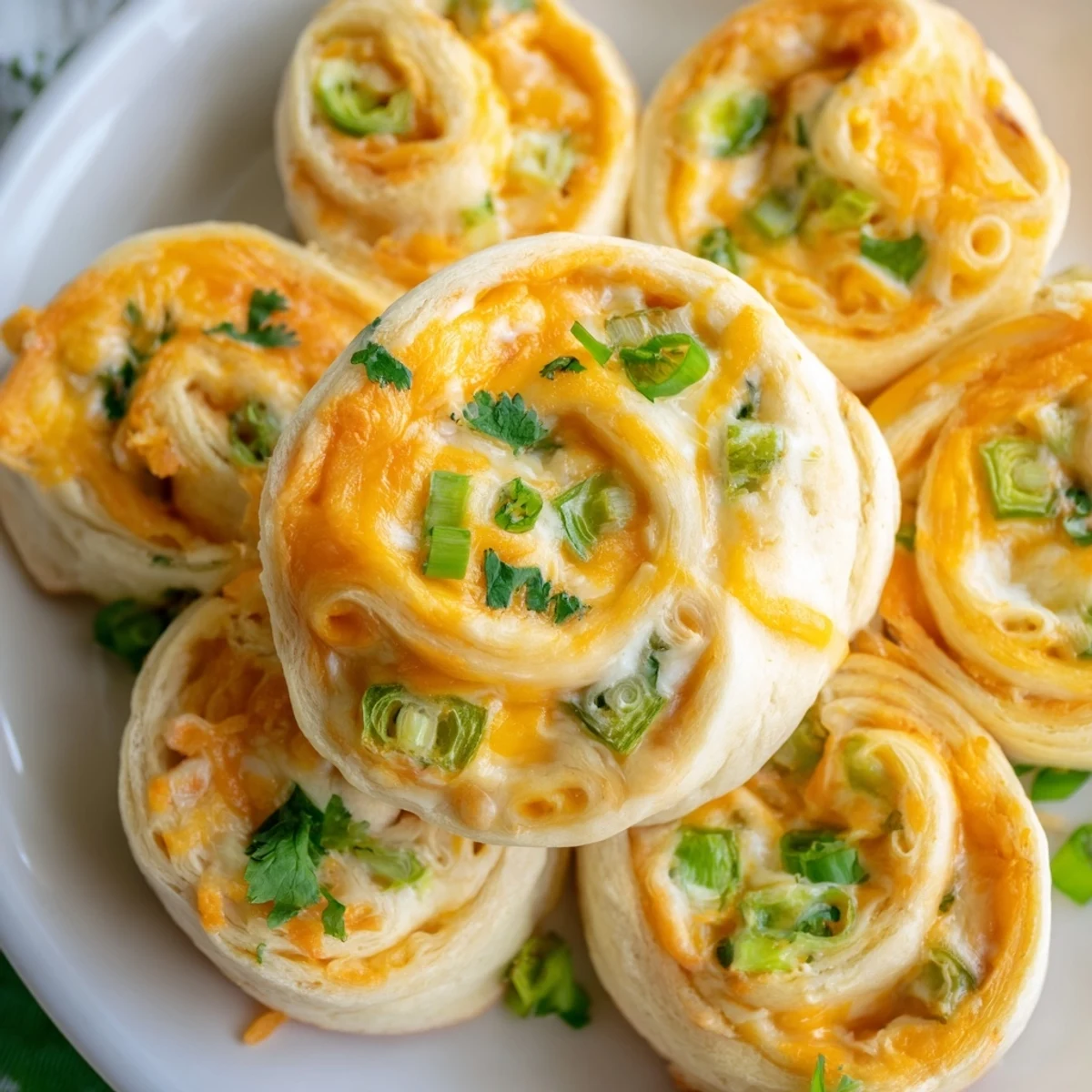 Warm spiral-shaped jalapeno popper pinwheels with melted cheddar cheese and buttery golden tortilla edges