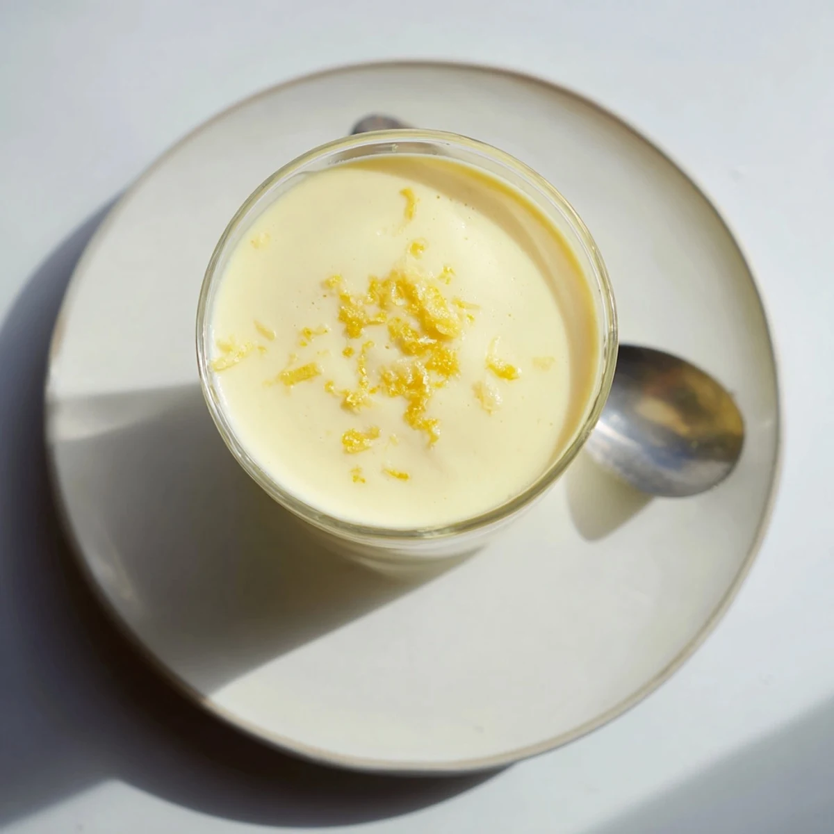 Individual chilled lemon posset ramekins with bright yellow hue and elegant presentation