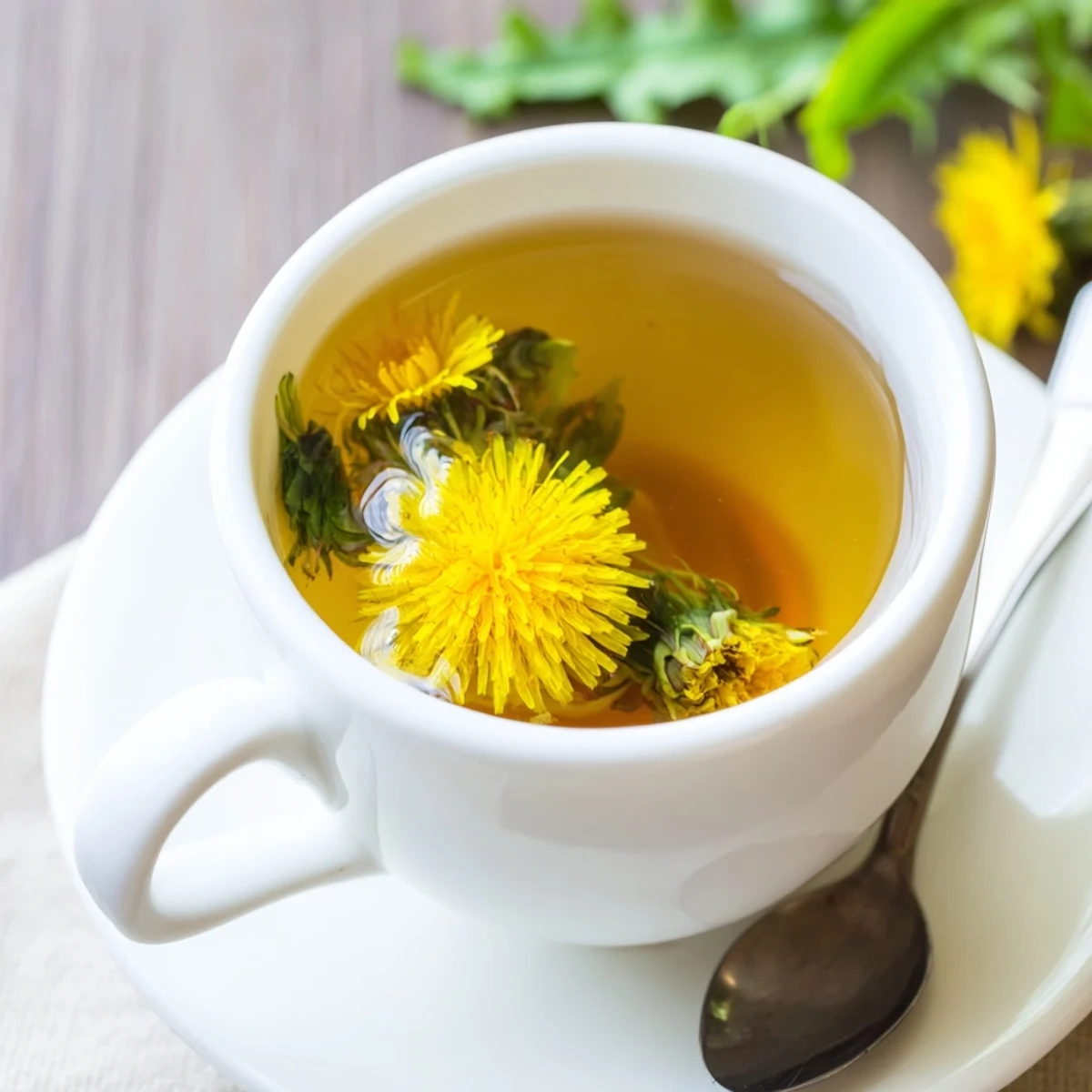 Warm herbal dandelion tea infusion poured into clear glass mug beside raw flower petals and honey drizzle