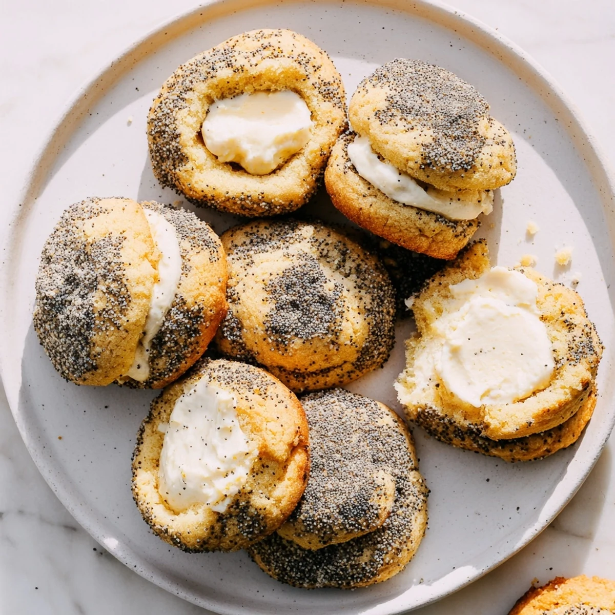 Baked lemon poppy seed cheesecake cookies sprinkled with poppy seeds on cooling rack