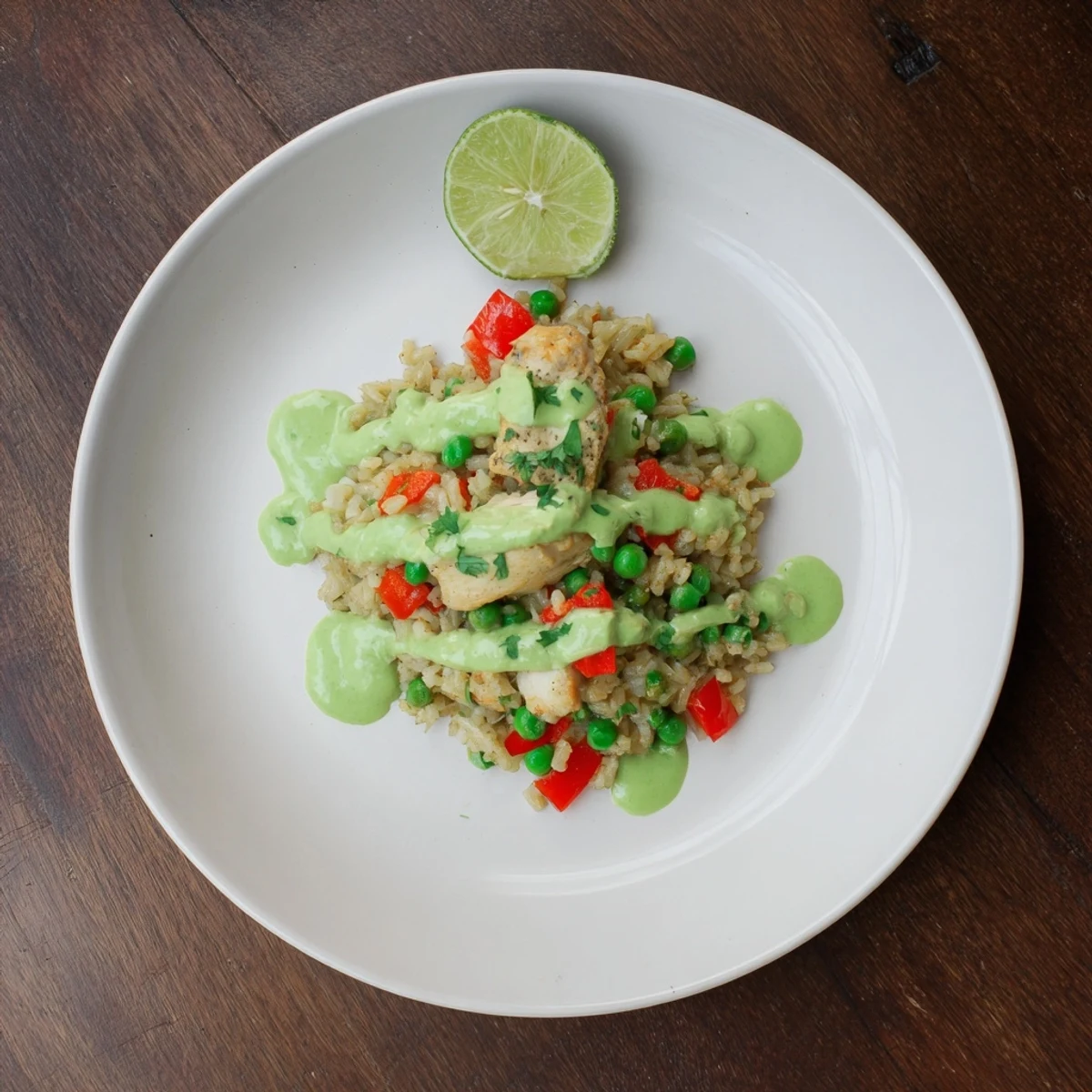 Golden Peruvian chicken rice with vibrant green sauce drizzled over tender meat and fluffy seasoned rice