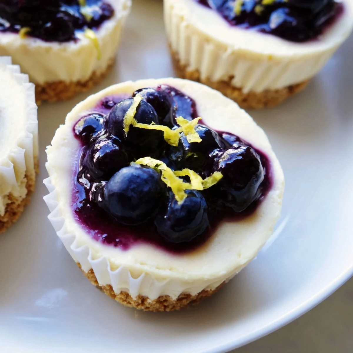 Creamy mini lemon blueberry cheesecakes swirling with tangy fruit topping in muffin liners