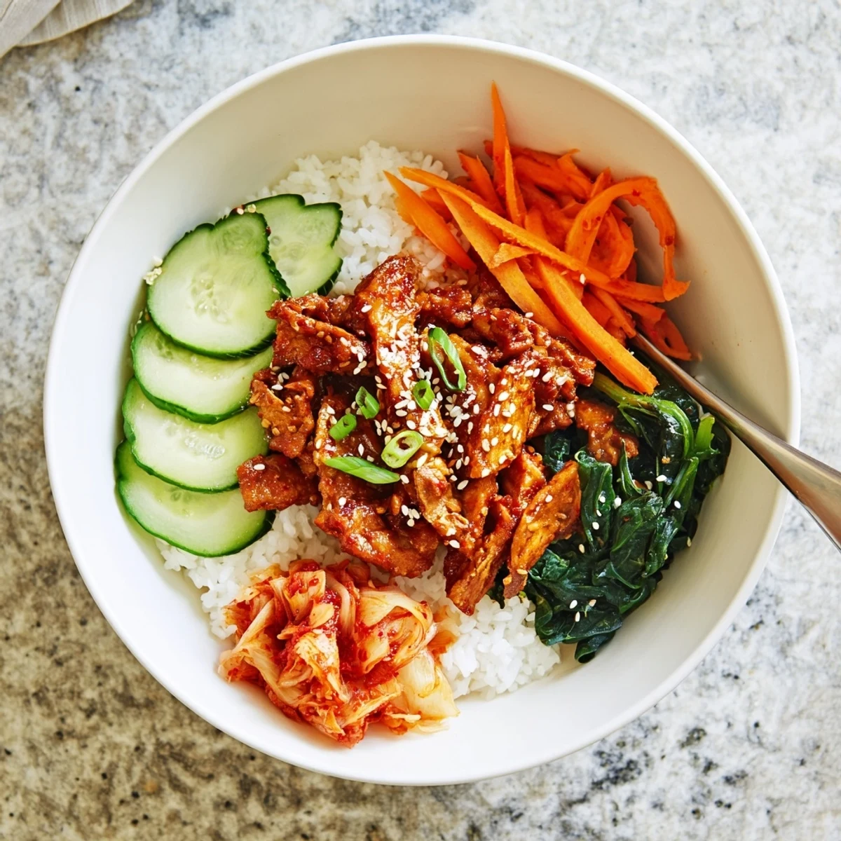 Crispy shredded tofu bulgogi bowl garnished with sesame seeds and fresh red chili slices