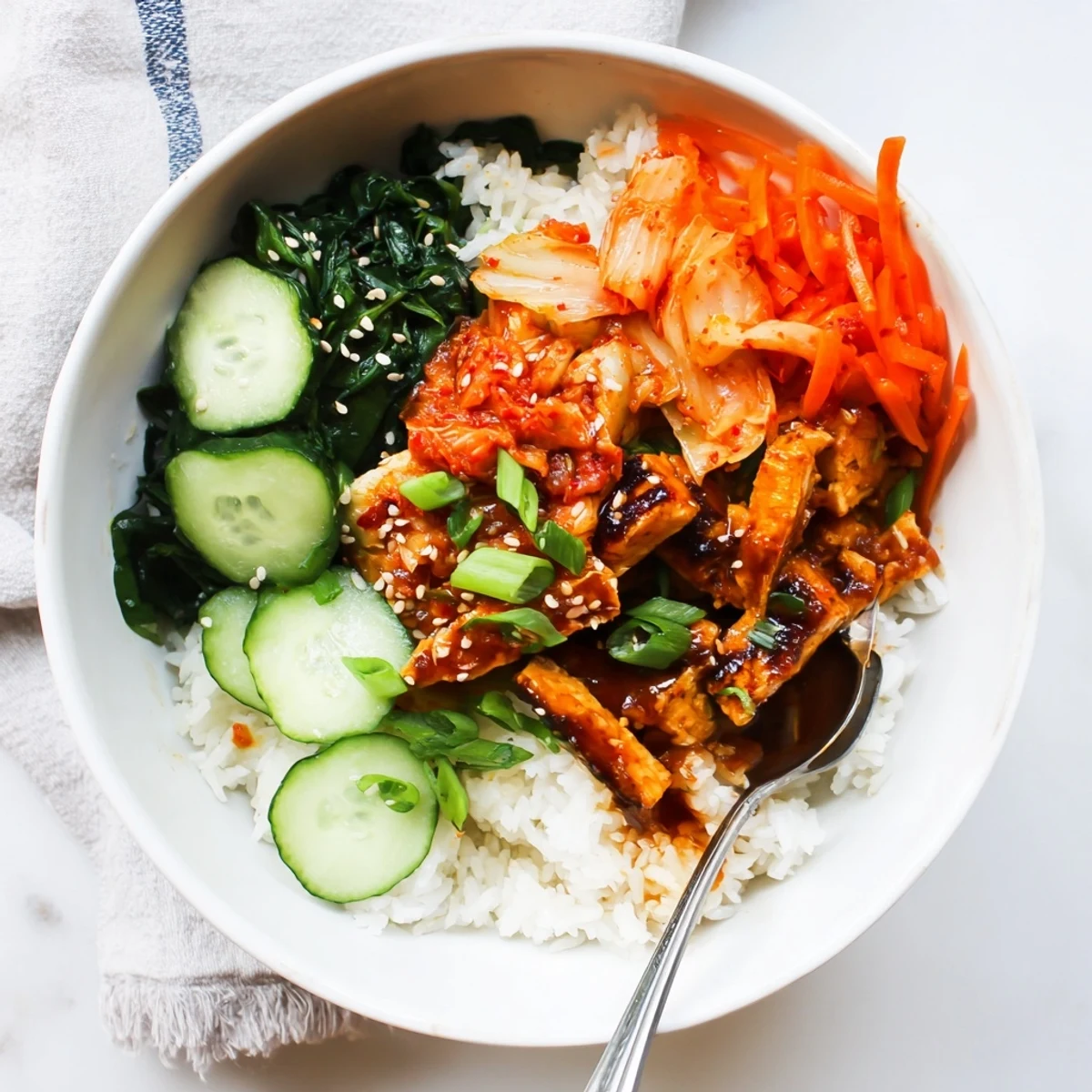 Vegan crispy shredded tofu bulgogi bowl drizzled with savory sweet sauce and kimchi