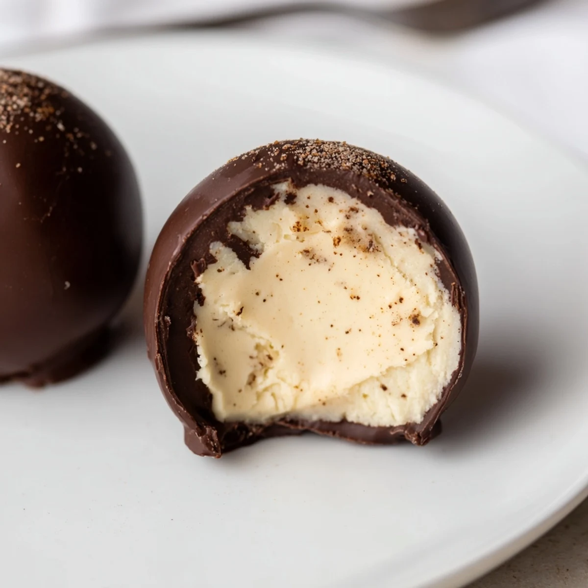 Hand rolled Dark Chocolate Eggnog Truffles on parchment, rich creamy centers visible