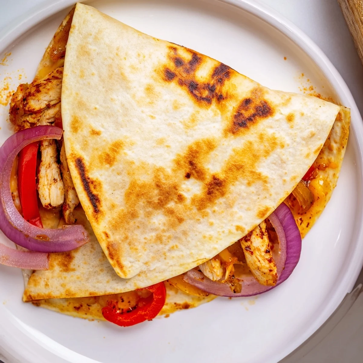 Warm Spicy Crispy Grilled Chicken Quesadilla sliced into wedges with salsa