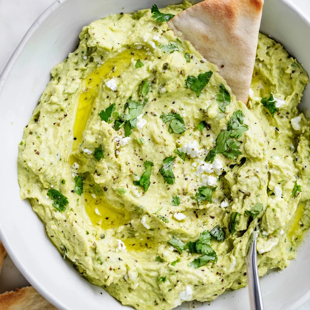 Creamy Avocado Feta Dip in bowl, silky texture, drizzled olive oil.
