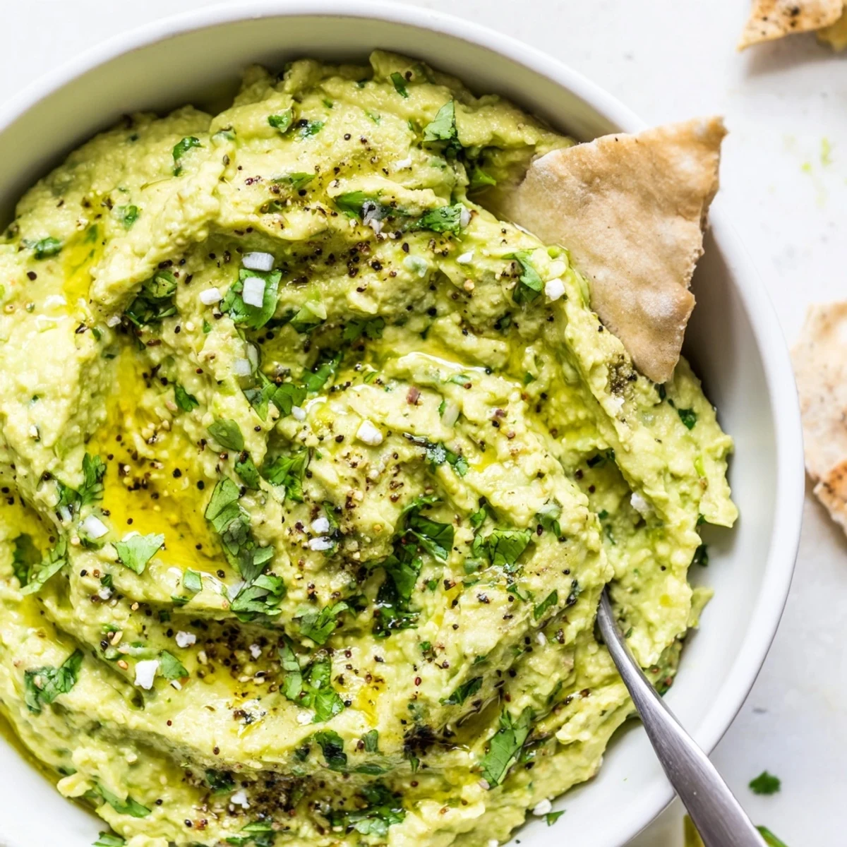 Chunky pita and crisp veggies surround Creamy Avocado Feta Dip for dipping.
