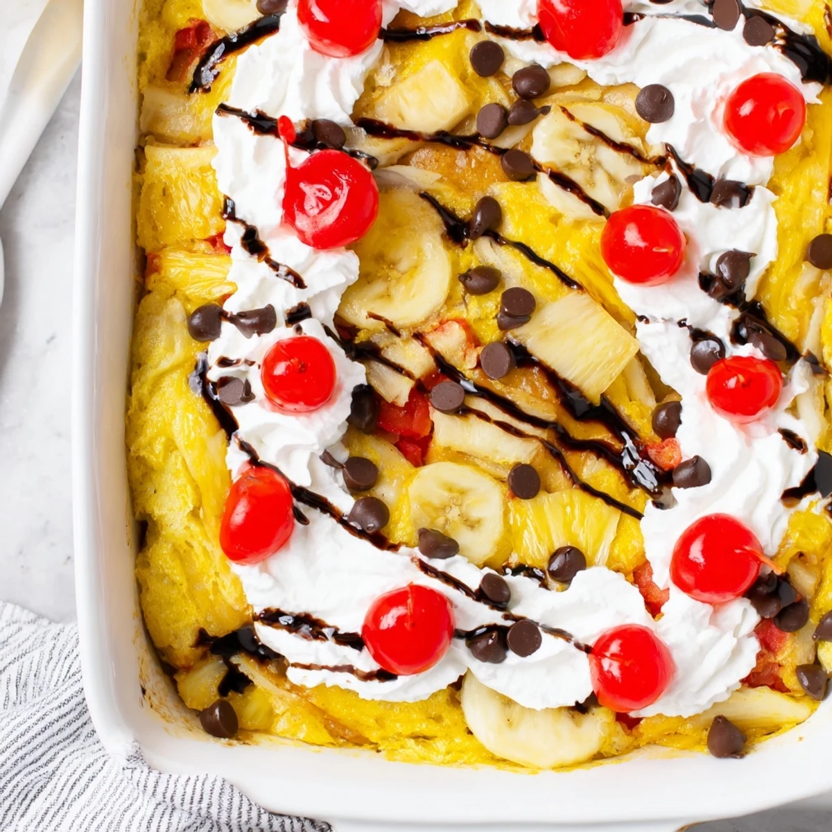 Gooey yellow cake layered with bananas, pineapple, and chocolate chips bubbling in a baking dish