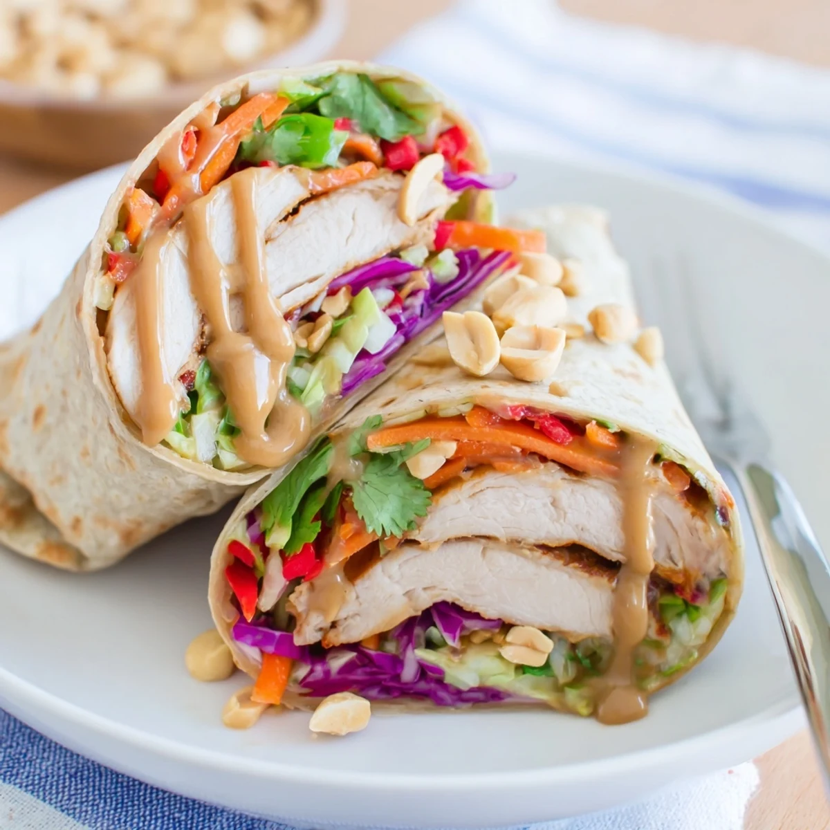 Soft tortillas holding Thai Peanut Chicken Wraps, glossy peanut sauce, cilantro
