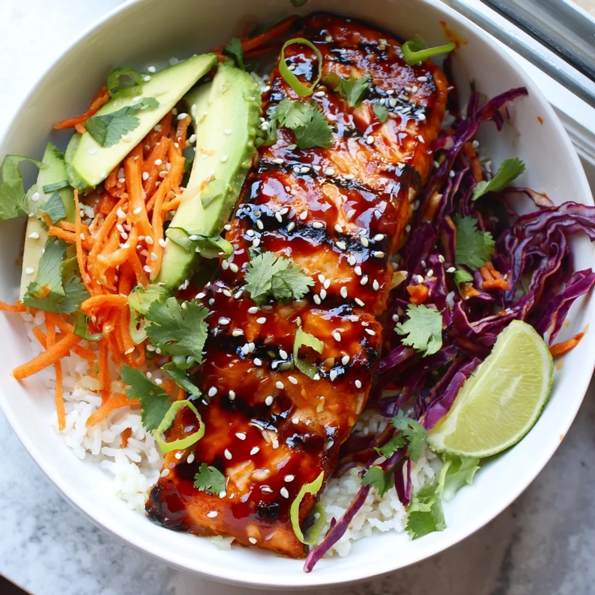 Glossy sriracha honey glazed salmon bowls topped with sesame seeds and crisp vegetables
