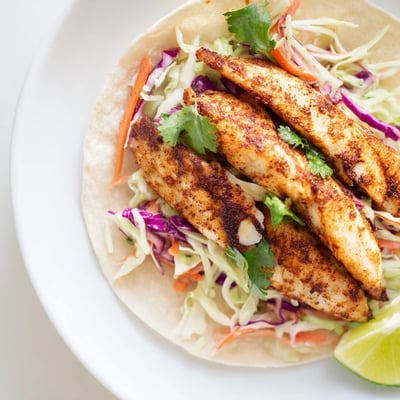 Cajun Spiced Fish Tacos with Slaw feature flaky white fish and crisp, tangy slaw on a plate.