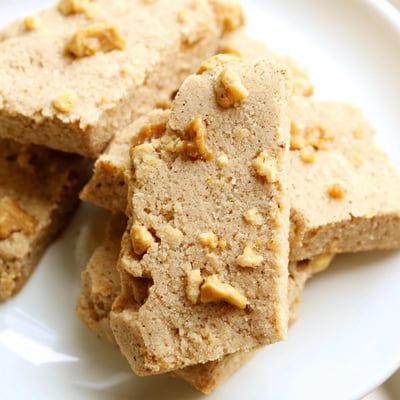 Crumbly espresso shortbread cookies studded with toffee bits on a parchment-lined baking sheet